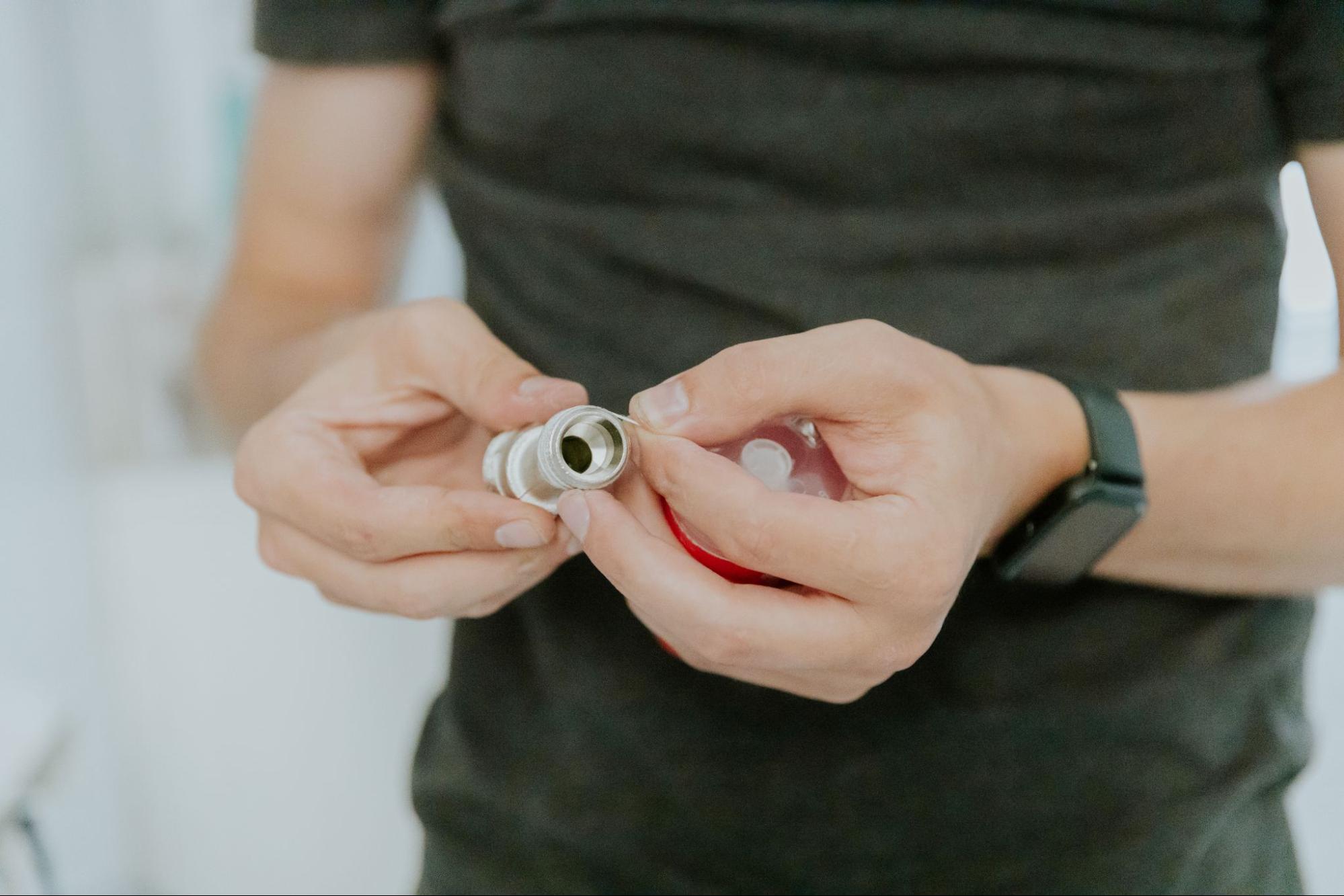 Plumber wrapping PTFE tape on threaded pipe fitting