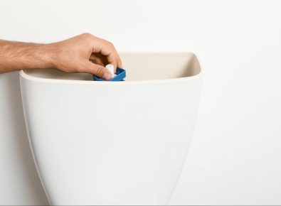 Inside of a toilet tank showing fill valve and flapper components