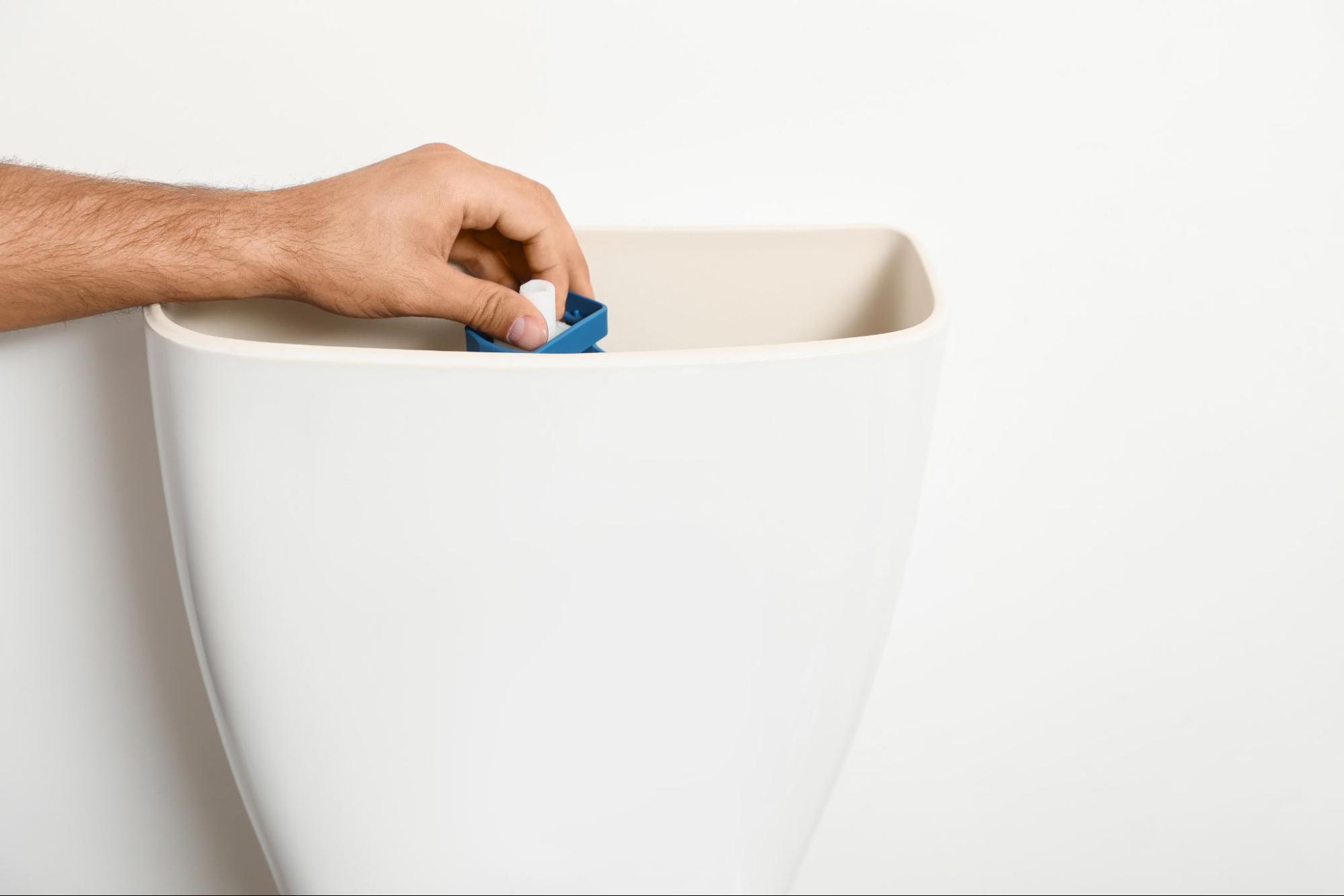 Inside of a toilet tank showing fill valve and flapper components